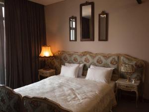 a bedroom with a bed and two lamps and a mirror at Esther House Museum in Odesa