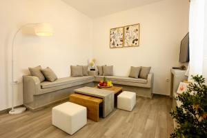 a living room with a couch and a table at Villa nectar 2 bedrooms 4 pers with Jacuzzi by MPS in Perivolos