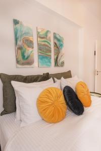 two orange pillows sitting on top of a bed at Inconceptual apartment in Paradeísion