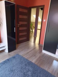 a hallway with two open doors and a blue rug at Markowia in Marki