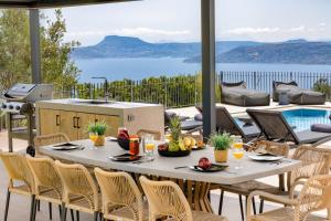 SeaSilia Luxury Villa في Korakiaí: طاولة وكراسي على فناء مطل على الماء