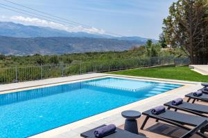 a swimming pool with a view of the mountains at SeaSilia Luxury Villa in Korakiaí