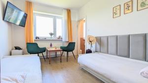 pokój hotelowy z 2 łóżkami, stołem i krzesłami w obiekcie Dom nad Jeziorem w mieście Szczedrzyk