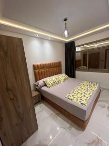 ein Schlafzimmer mit einem Bett mit gelben und gelben Kissen in der Unterkunft appartement de luxe hay almatar 3 in Nador