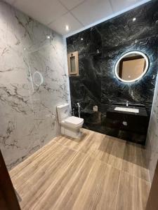 ein Badezimmer mit Toilette, Waschbecken und Spiegel in der Unterkunft appartement de luxe hay almatar 3 in Nador