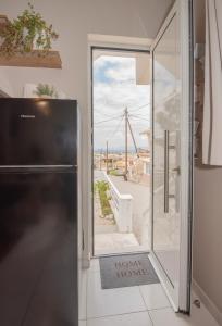 a kitchen with a refrigerator and a view of a balcony at Inconceptual apartment in Paradeísion