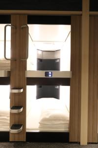 a room with two bunk beds in a room at Cabin & Capsule Hotel J-SHIP Osaka Namba in Osaka