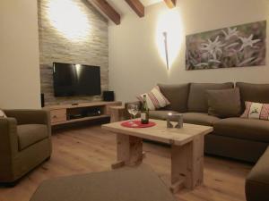 salon z kanapą, stołem i telewizorem w obiekcie Chalet Edelweiss w mieście Steibis