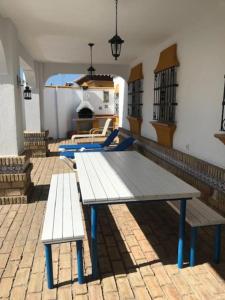 una mesa de picnic y dos bancos en un patio de ladrillo en El Magnolio, en Chiclana de la Frontera