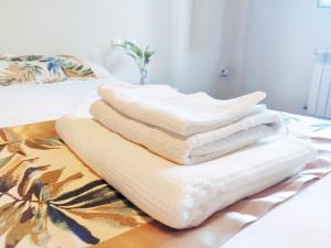 a pile of towels sitting on a bed at Casa de Ribeira Sacra con calefacción in Pantón