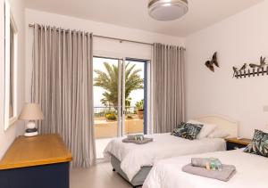 1 Schlafzimmer mit 2 Betten und einem großen Fenster in der Unterkunft 105 Kings Palace - Fabulous 2 Bed, 2 bath, Large Patio with Garden - Sea Views in Paphos City