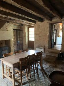 a dining room with a wooden table and chairs at Charmante maison périgourdine in Granges-dʼAns