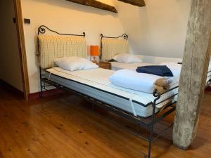 two twin beds in a room with wooden floors at Charmante maison périgourdine in Granges-dʼAns