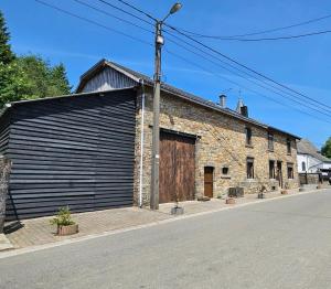 um grande edifício de tijolos com uma grande garagem em Ferme La Joye em Houffalize