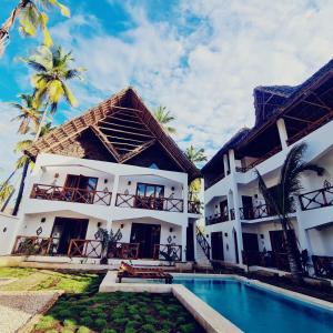 a villa with a swimming pool in front of a building at Mambo Cabana in Pwani Mchangani