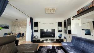 ein Wohnzimmer mit einem Sofa und einem Flachbild-TV in der Unterkunft Unique Munich Apartment in Unterhaching