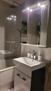 ein weißes Badezimmer mit einem Waschbecken und einem Spiegel in der Unterkunft Unique Munich Apartment in Unterhaching
