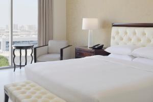 une chambre d'hôtel avec un lit, une chaise et une fenêtre dans l'établissement Delta Hotels by Marriott Dubai Investment Park, à Dubaï