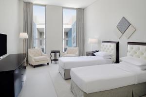 a hotel room with two beds and a flat screen tv at Delta Hotels by Marriott Dubai Investment Park in Dubai