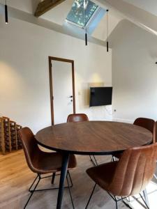 een eetkamer met een houten tafel en stoelen bij Appartement Parkzicht in Geel