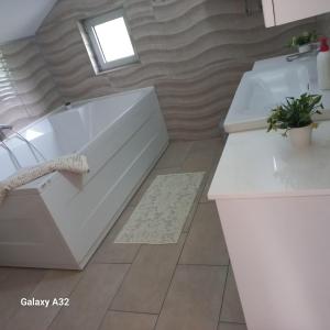 a bathroom with two sinks and a bath tub at Kuća za odmor Lohovo in Bihać