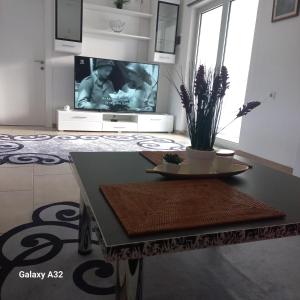 a living room with a table and a tv at Kuća za odmor Lohovo in Bihać