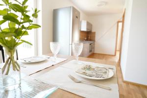 Birkfeld的住宿－Athecada Apartments，一张餐桌,配有两个盘子和一个花瓶
