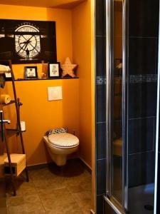 a bathroom with a toilet and a clock on the wall at Appartement romantique avec jacuzzi et terrasse in Perpignan