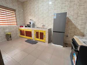 cocina con encimera amarilla y nevera en Appartement moderne 2chambres, en Cotonou