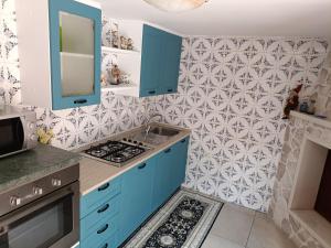 una cucina con armadi blu e parete piastrellata di LA CASA DEI DESIDERI a Oria