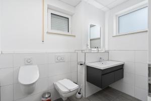 フリードリヒスハーフェンにあるFerien & Business Apartments Hotel Adlerの白いバスルーム(トイレ、シンク付)