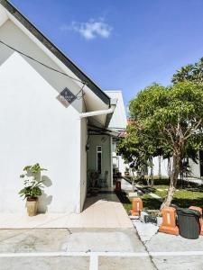 una casa bianca con un cartello sul lato. di Belukar Lodges Private Homestay a Pantai Cenang