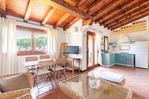 a living room with a table and chairs and a kitchen at Residenze Coda Cavallo - Punta Aldia - Casa delle Sughere in Puntaldia