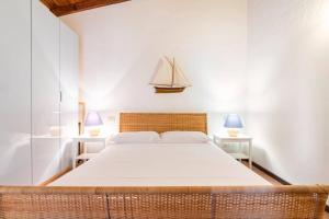 a bedroom with a large bed with two lamps at Residenze Coda Cavallo - Punta Aldia - Casa delle Sughere in Puntaldia