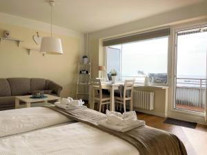 1 dormitorio con 1 cama y sala de estar con mesa en Atlantischer Hof 26, Königstraße, en Wyk auf Föhr