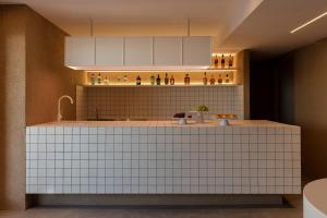 cocina con encimera de azulejos blancos en Neo Suites, en Fira