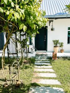 a pathway leading to a house with a black door at Belukar Lodges Private Homestay in Pantai Cenang