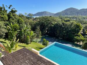 einen Pool mit Blick auf ein Resort in der Unterkunft Apartamento 3 suítes Camburi in Camburi