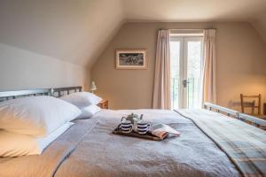 a bedroom with a bed with a tray of shoes on it at Gardiners Cottage Barn in Eye