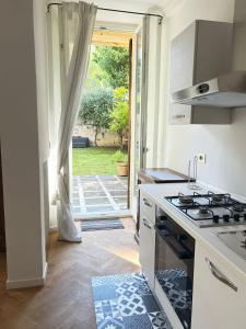 a kitchen with a stove top oven next to a door at Vagabunda Sea & Garden in Pesaro