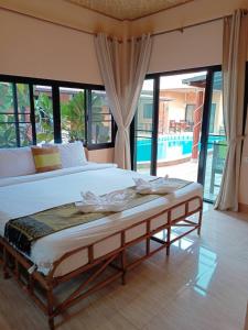 a large bed in a room with a large window at Panisara Pool Villa Resort Huahin in Hua Hin
