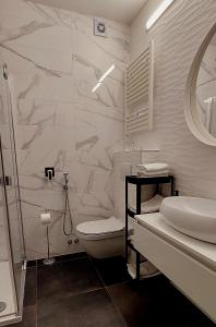 La salle de bains blanche est pourvue d'une douche et de toilettes. dans l'établissement Apartaments Victoria, à Poreč