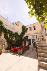 eine Terrasse mit Tischen und Stühlen in einem Gebäude in der Unterkunft Osmanlı Konağı - Şerif Paşa Butik Otel in Şanlıurfa