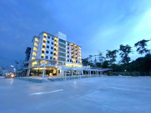 春武里的住宿－GEEN Hotel Chonburi，一座大型建筑,前面设有停车场