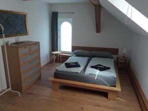 a bedroom with a bed and a dresser and a window at Ferienwohnung Schaeferhof, die Natur vor der Haustüre in Cottbus