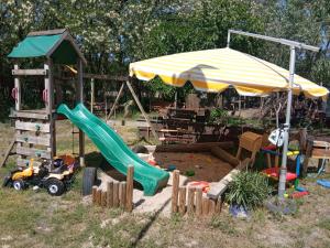 a playground with a slide and an umbrella at GRÜNZEIT Ferienwohnung, die Natur vor der Haustüre in Cottbus