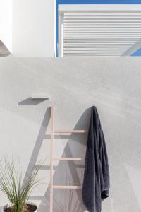 ein Bad mit einem an der Wand hängenden Handtuch in der Unterkunft Neo Suites in Fira
