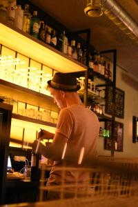 a man in a hat standing at a bar at Letzz Sleep in Bruges