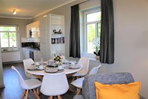 Un comedor con una mesa y sillas blancas. en Fehmarnhaus 4, en Fehmarn