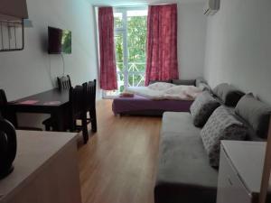 ein Wohnzimmer mit einem Sofa, einem Tisch und einem Schreibtisch in der Unterkunft Gerber 2 in Sonnenstrand